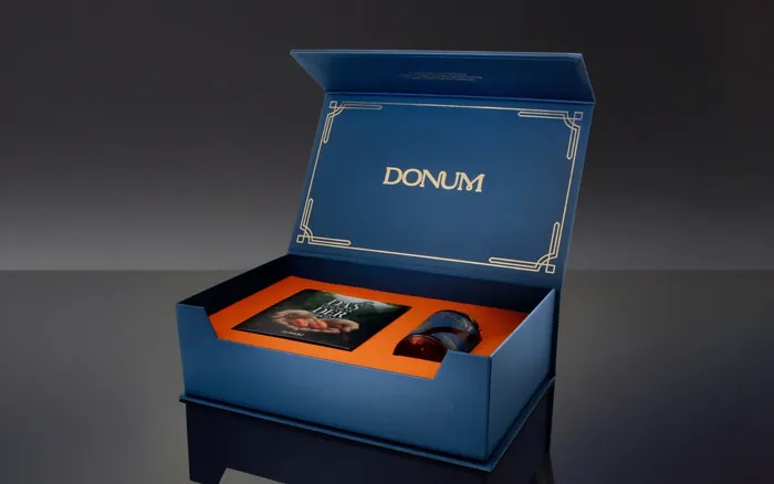 Geöffnete Geschenkbox mit Booklet und Flakon
