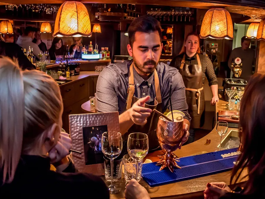 Barkeeper mixt an einer belebten Hotelbar Cocktails